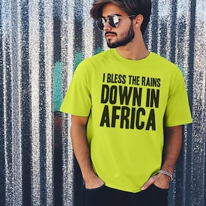 Op de afbeelding: Een neon groen T-shirt met de tekst "I bless the rains down in Africa" in zwart gedrukt.