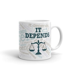 Pode incluir: Caneca de cerâmica branca com um design preto e azul-petróleo. O design apresenta uma balança de justiça e as palavras "It Depends" repetidas em um padrão circular.