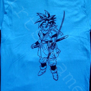 May include: A blue t-shirt with a black graphic print of a character from a video game holding a sword.
