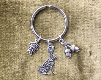 May include: Silver key chain with a charm of a rabbit, an acorn, and an oak leaf.