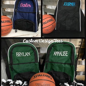 May include: Four personalized basketball backpacks with white trim. Two backpacks are green with white lettering, one is black with blue lettering, and one is blue with pink lettering. Each backpack has a mesh pocket on the front. A basketball with the Spalding logo is in front of the green backpacks.