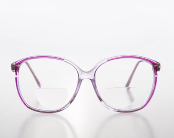 Puede incluir: Gafas de plástico transparente con montura rosa brillante. Las gafas tienen una forma redondeada y de gran tamaño.