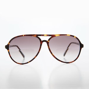 May include: Tortoise shell aviator sunglasses with brown gradient lenses.
