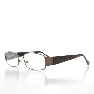 May include: A pair of brown metal spectacles with clear lenses. The spectacles have a rectangular shape and a simple design.