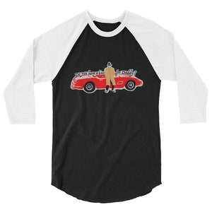 May include: A black and white baseball tee shirt with a red, white, and black image of a man in a fedora standing next to a red sports car. The text "Do you have a kiss for Daddy?" is printed on the shirt.