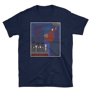 Peut inclure: Un t-shirt bleu marine avec une illustration de dessin animé d'une femme en robe rouge tenant un parapluie et volant au-dessus d'une ville. La femme est entourée d'hommes en chapeaux et manteaux debout sur les toits.