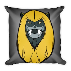 Puede incluir: Una almohada gris con una criatura de pelo amarillo, ojos negros y dientes afilados, con una cara gris. La criatura tiene una nariz negra y una boca negra con colmillos blancos.