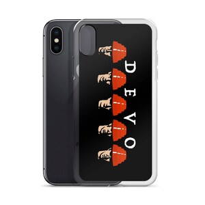 Op de afbeelding: Een transparante telefoonhoes met een zwarte achtergrond en een wit DEVO-logo. Vijf rode hoeden met witte contouren zijn op elkaar gestapeld, met een gezicht dat onder elke hoed vandaan kijkt.