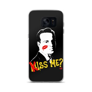 Può includere: Custodia per telefono nera con un ritratto in bianco e nero, un segno di bacio con rossetto rosso e le parole "Kiss Me?" in giallo e rosso. Il design include "-SH" sotto.