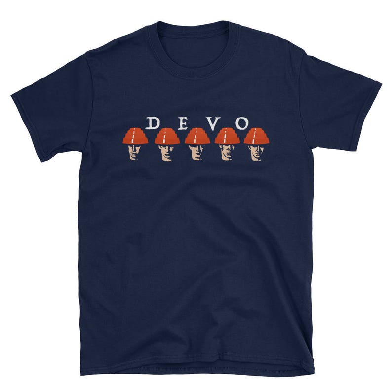 Peut inclure: Un t-shirt bleu marine avec le mot "DEVO" imprim&eacute; en lettres blanches et une rang&eacute;e de cinq personnages portant des casques orange.