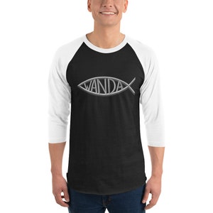 Peut inclure: Un t-shirt de baseball noir et blanc à manches 3/4. Le t-shirt présente un symbole de poisson argenté avec le mot "WANDA" à l'intérieur du poisson.
