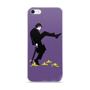 Puede incluir: Una funda de iPhone morada con una ilustración en blanco y negro de un hombre con traje y sombrero pisando una cáscara de plátano. El hombre lleva un paraguas y un maletín. Hay cáscaras de plátano amarillas en el suelo.