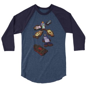 Könnte beinhalten: Ein marineblaues und heidegraues Baseball-T-Shirt mit einem Design aus sieben Holzfiguren in verschiedenen Posen. Die Figuren sind in verschiedenen Farben bemalt, darunter Rot, Blau, Gelb und Grün.