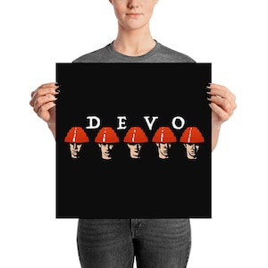 May include: A black poster with the word "DEVO" in white letters and five red and white helmets with faces in them.