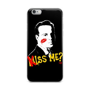 May include: Black and white illustration of a man with a red lipstick mark on his cheek. The text "Kiss Me? -SH-" is written in yellow and red letters below the man.