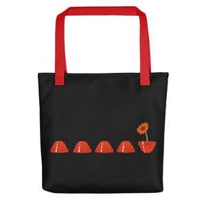 May include: Black tote bag with red handles and a graphic of five red jelly molds and a single orange flower in a red jelly mold.