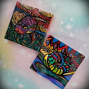 May include: Two small, colorful canvas paintings with abstract designs. The paintings feature bright colors, including red, yellow, green, blue, and purple. The designs are intricate and detailed, with a focus on geometric shapes and patterns.