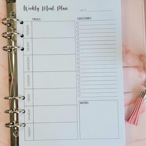 Peut inclure: Un planificateur de repas hebdomadaire blanc avec une section pour les repas et une section pour les courses. Le planificateur comprend une section pour les notes et un espace pour écrire le numéro de la semaine.