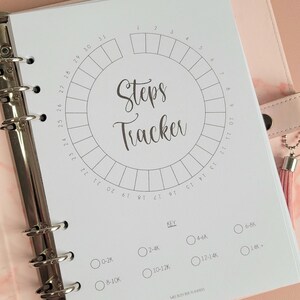 Peut inclure: Une page de planificateur imprimable blanche avec un cercle divisé en 31 sections pour suivre les pas. Le cercle est intitulé "Steps Tracker". En dessous du cercle se trouve une clé avec différentes plages de pas : 0-2 000, 2 000-4 000, 4 000-6 000, 6 000-8 000, 8 000-10 000, 10 000-12 000, 12 000-14 000 et 14 000 +.