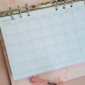 May include: A white monthly planner with a black grid and the words "MONTHLY PLANNER" at the top. The days of the week are listed across the top: Monday, Tuesday, Wednesday, Thursday, Friday, Saturday, and Sunday.