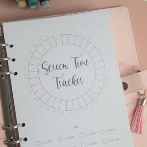 Puede incluir: Una página de planificador imprimible blanca con un círculo dividido en 31 secciones para hacer un seguimiento del tiempo de pantalla. El círculo está etiquetado como "Screen Time Tracker". Debajo del círculo hay una clave con diferentes incrementos de tiempo: 1 hora, 2 horas, 3 horas, 4 horas, 7 horas y 8 horas o más.