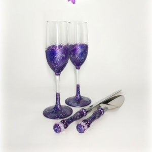 May include: Two champagne flutes and a cake serving set with purple glitter accents. The flutes and serving set have a matching design, with glitter on the base and handles. The text "Maryana's Bridal" is in the upper right corner.