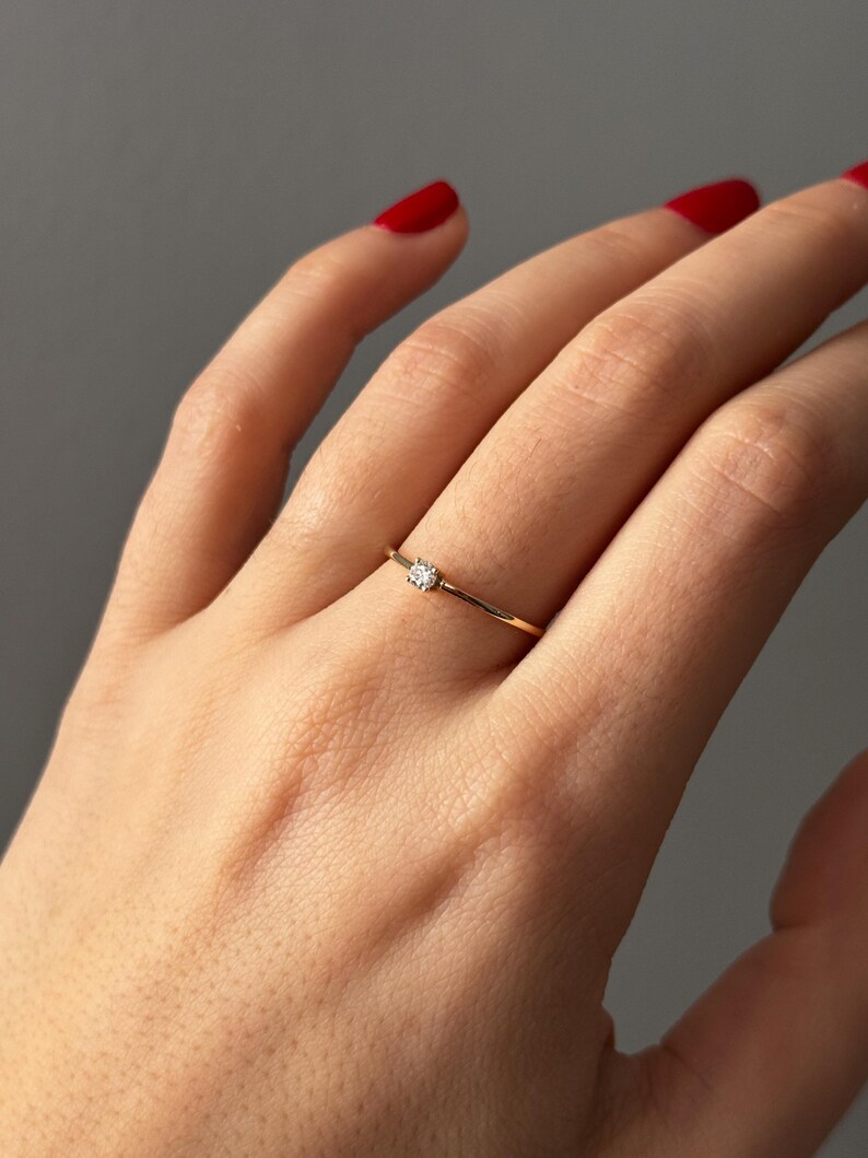 14k solid gold ring with a 4 prong set 0.10 carat 3 mm diamond .perfect as an everyday and stacking options, minimalistic promise ring displayed on a model