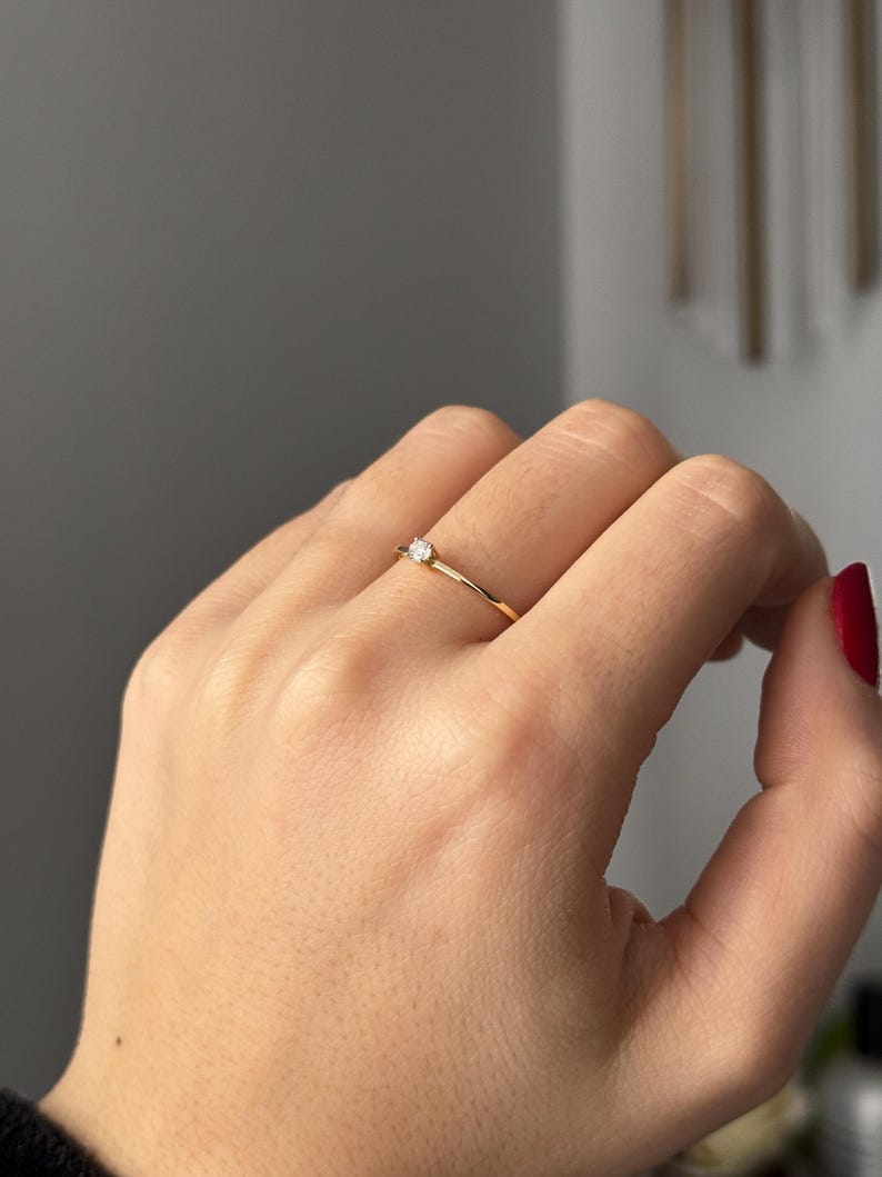 14k solid gold ring with a 4 prong set 0.10 carat 3 mm diamond .perfect as an everyday and stacking options, minimalistic promise ring displayed on a model side view