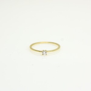 14k solid gold ring with a 4 prong set 0.10 carat 3 mm diamond .perfect as an everyday and stacking options, minimalistic promise ring displayed on a white background