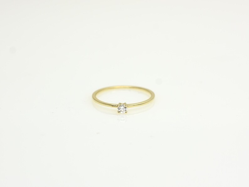 14k solid gold ring with a 4 prong set 0.10 carat 3 mm diamond .perfect as an everyday and stacking options, minimalistic promise ring displayed on a white background