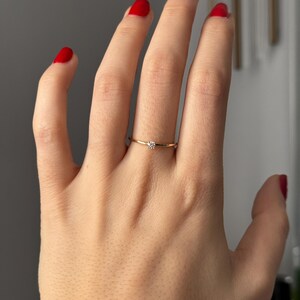 14k solid gold ring with a 4 prong set 0.10 carat 3 mm diamond .perfect as an everyday and stacking options, minimalistic promise ring displayed on a model