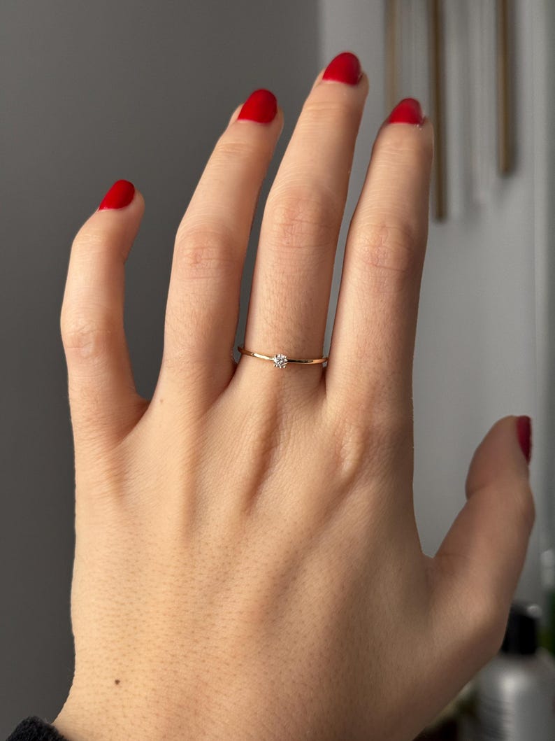 14k solid gold ring with a 4 prong set 0.10 carat 3 mm diamond .perfect as an everyday and stacking options, minimalistic promise ring displayed on a model