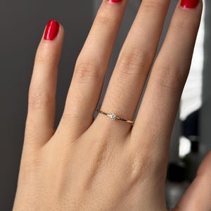14k solid gold ring with a 4 prong set 0.10 carat 3 mm diamond .perfect as an everyday and stacking options, minimalistic promise ring displayed on a model