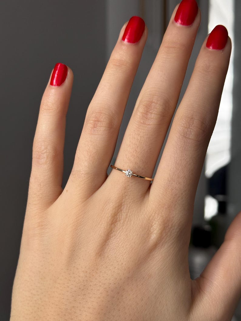 14k solid gold ring with a 4 prong set 0.10 carat 3 mm diamond .perfect as an everyday and stacking options, minimalistic promise ring displayed on a model