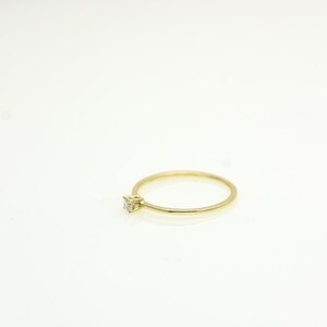 14k solid gold ring with a 4 prong set 0.10 carat 3 mm diamond .perfect as an everyday and stacking options, minimalistic promise ring displayed on a white background