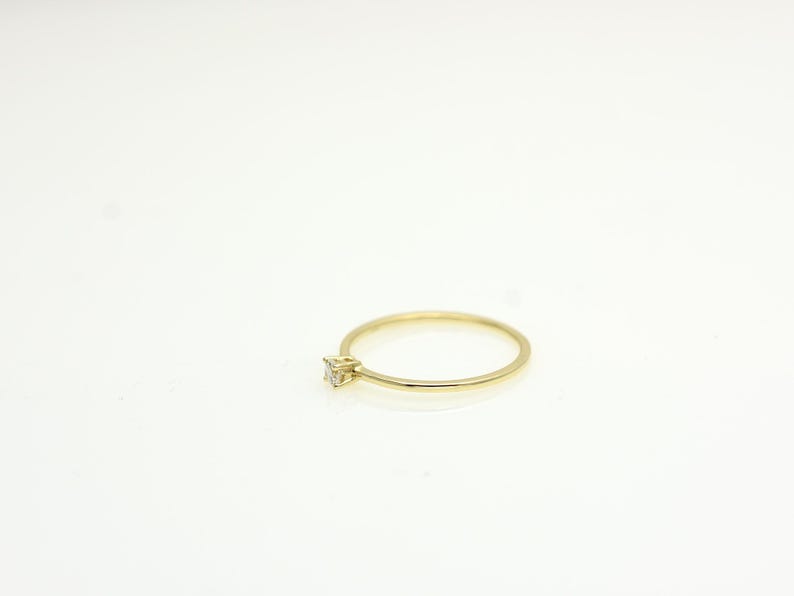 14k solid gold ring with a 4 prong set 0.10 carat 3 mm diamond .perfect as an everyday and stacking options, minimalistic promise ring displayed on a white background