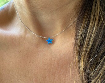 May include: A silver chain necklace with a blue opal star pendant.