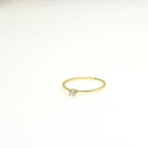 14k solid gold ring with a 4 prong set 0.10 carat 3 mm diamond .perfect as an everyday and stacking options, minimalistic promise ring displayed on a white background