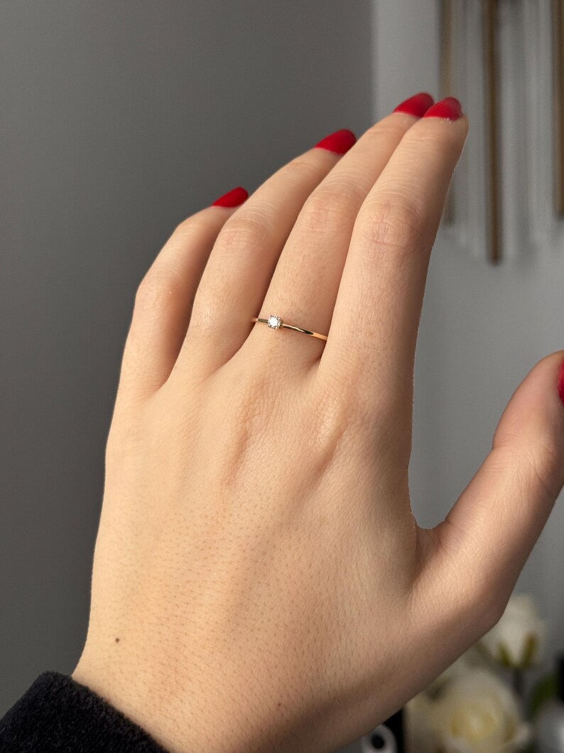 14k solid gold ring with a 4 prong set 0.10 carat 3 mm diamond .perfect as an everyday and stacking options, minimalistic promise ring displayed on a model