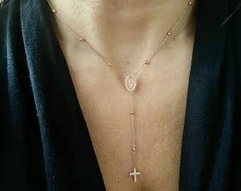 Puede incluir: Un collar de cadena de oro rosa con un pequeño colgante ovalado que presenta un icono religioso y un pequeño dije de cruz al final.