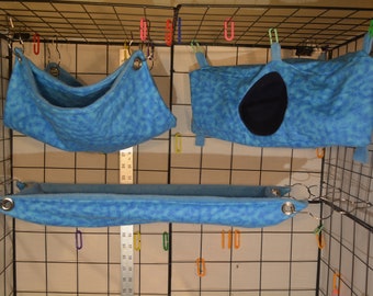 May include: Three blue fleece hanging beds for small pets, with two of the beds having a round opening and the third bed being a long, flat hammock.