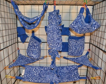Puede incluir: Un conjunto de hamacas colgantes y bolsas con estampado azul y blanco para mascotas pequeñas. Las hamacas están hechas de tela suave y tienen una variedad de formas y tamaños.