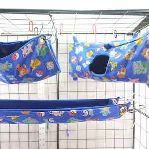May include: Three blue and white fabric hanging beds for small pets. The beds feature a Pokemon character print.