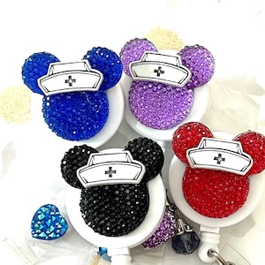May include: Four colorful rhinestone nurse Mickey Mouse themed retractable badge reels with a silver heart and medical symbol charm.