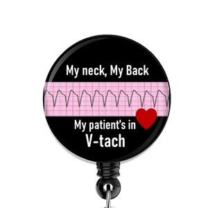 May include: Black and white badge holder with a black button and a clear plastic clip. The badge features a pink and white EKG with a red heart and the text "My neck, My Back My patient's in V-tach".