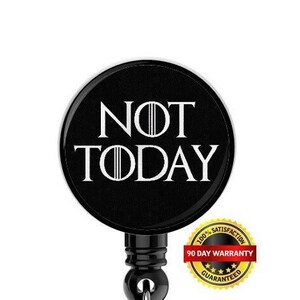 Può includere: Portabadge retrattile nero con una grafica bianca che dice "NOT TODAY". Il portabadge ha un clip in plastica trasparente e un adesivo dorato di garanzia di 90 giorni.