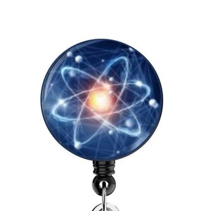 May include: A blue and silver retractable badge holder with a round atom design. The atom is made of glowing white lines on a dark blue background.