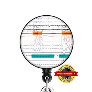 May include: A black and silver retractable badge holder with a round, white and black image of an electrocardiogram. The image has red, orange, and blue lines. The badge holder has a 90-day warranty.