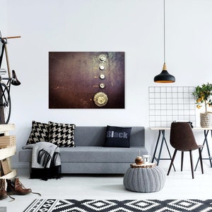 Puede incluir: Un interior de sala de estar moderno con un sof&aacute; gris, una alfombra con estampado en blanco y negro, un estante de madera con una bicicleta colgada, una l&aacute;mpara colgante negra, un peque&ntilde;o &aacute;rbol en maceta y una impresi&oacute;n de lienzo enmarcada con un fondo oxidado y cinco objetos met&aacute;licos circulares.