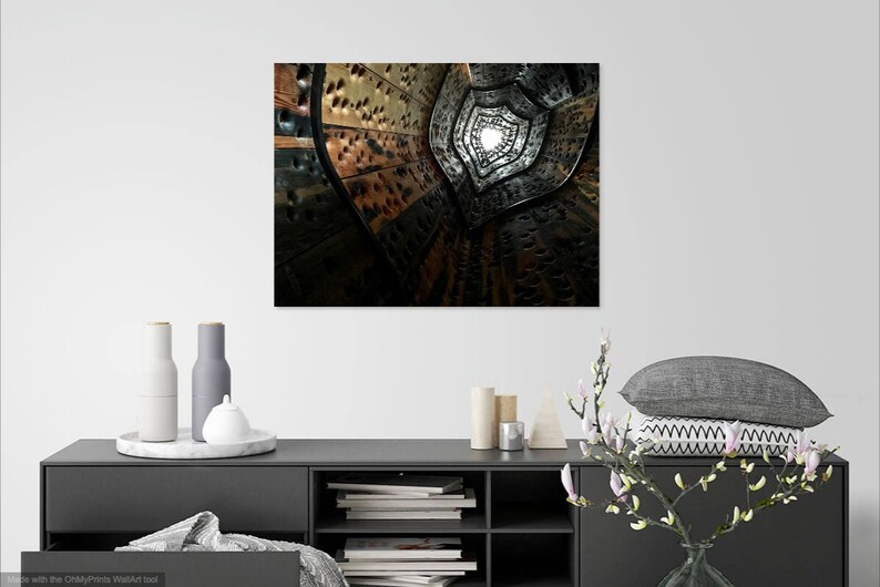 May include: A black and white abstract photograph of a spiral staircase with a light at the end of the tunnel.